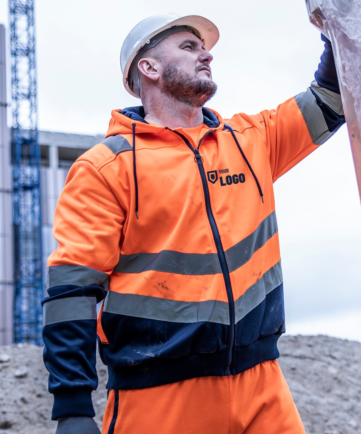 Construction worker in an orange hi-vis hoodie with a logo printed on the left chest